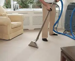 Carpet cleaning professional removing dirt and stains with a hot-water extraction tool in a home, Arvada, CO.