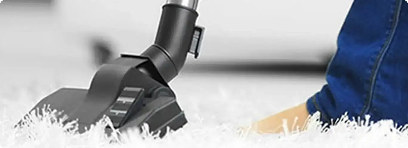 Close-up of a professional vacuuming a white carpet in Morrison.